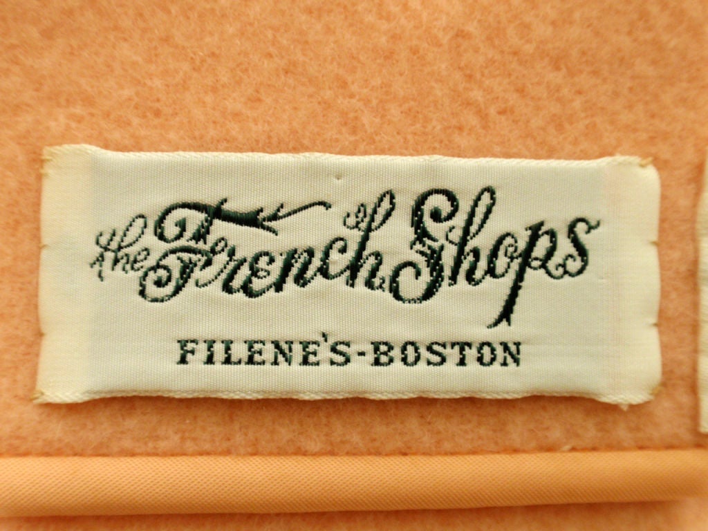 This is a charming women's overcoat from Filene's, Boston. It is made of a peach colored heavy wool and is unlined. There are 2 big patch pockets on the front that are also unlined. TIt buttons down the front with 5 big buttons and has button
