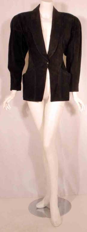 This is a black suede jacket by Alaia, from the 1980's. The jacket has two open front pockets, one center snap closure, silk lining, and shoulder pads.

Measurements:

Length (Shoulder to hem): 27