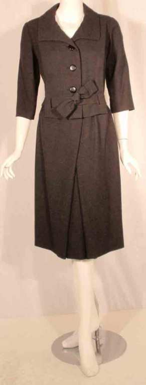 This is a gray wool dress by Christian Dior for Neiman Marcus, from the 1960's. The dress has a belt which loops through the jacket, no lining, and buttons down the bodice.

Measurements:

Length(Shoulder to hem): 41 1/2