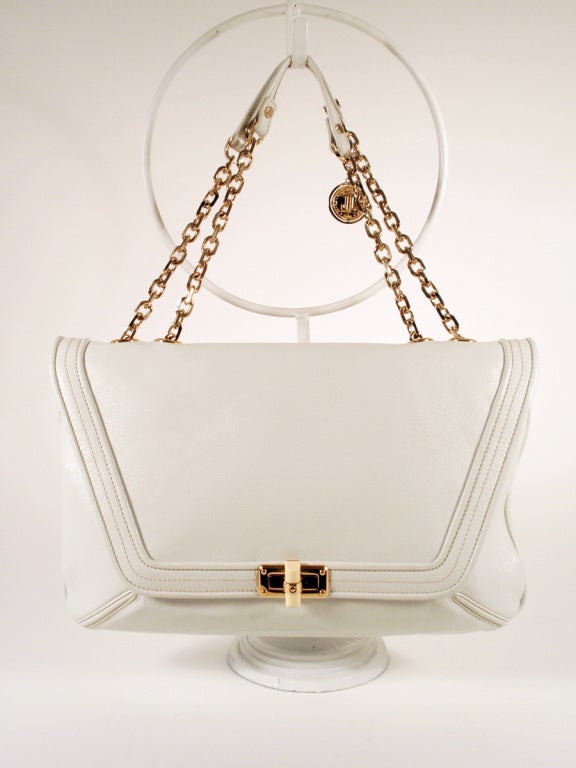 This is a lovely handbag from Lanvin. It is made of white leather and lined with white lining, with the Lanvin logo. The strap is a metal gold tone chain with leather, and can be adjusted to be a double strap handbag or a single strap shoulder bag.