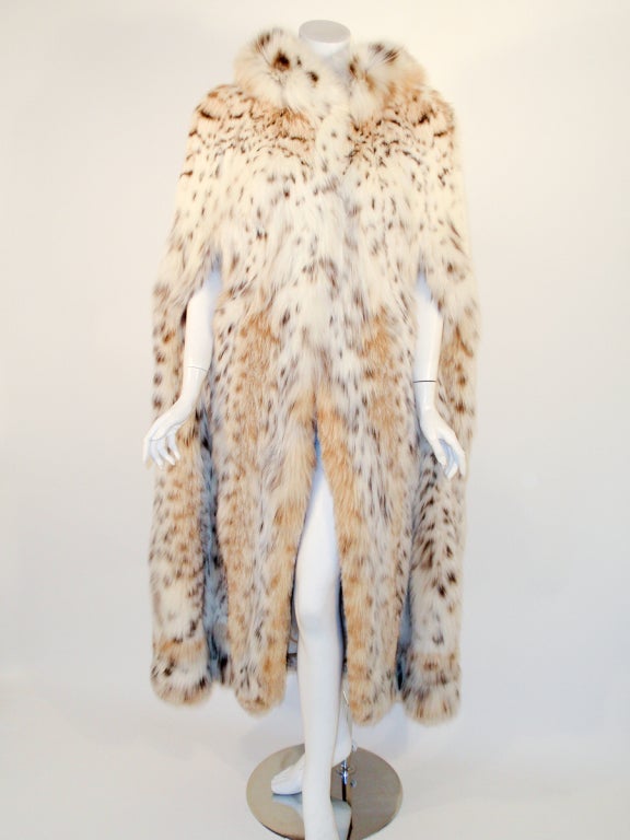 This a gorgeous long full length fur cape from Max Reby. It is made of the softest lynx fur and has a heavy cream satin lining. There are 2 slits in the front for arm holes, an inside pocket and 3 hook and eyes on the front for closure (these can be