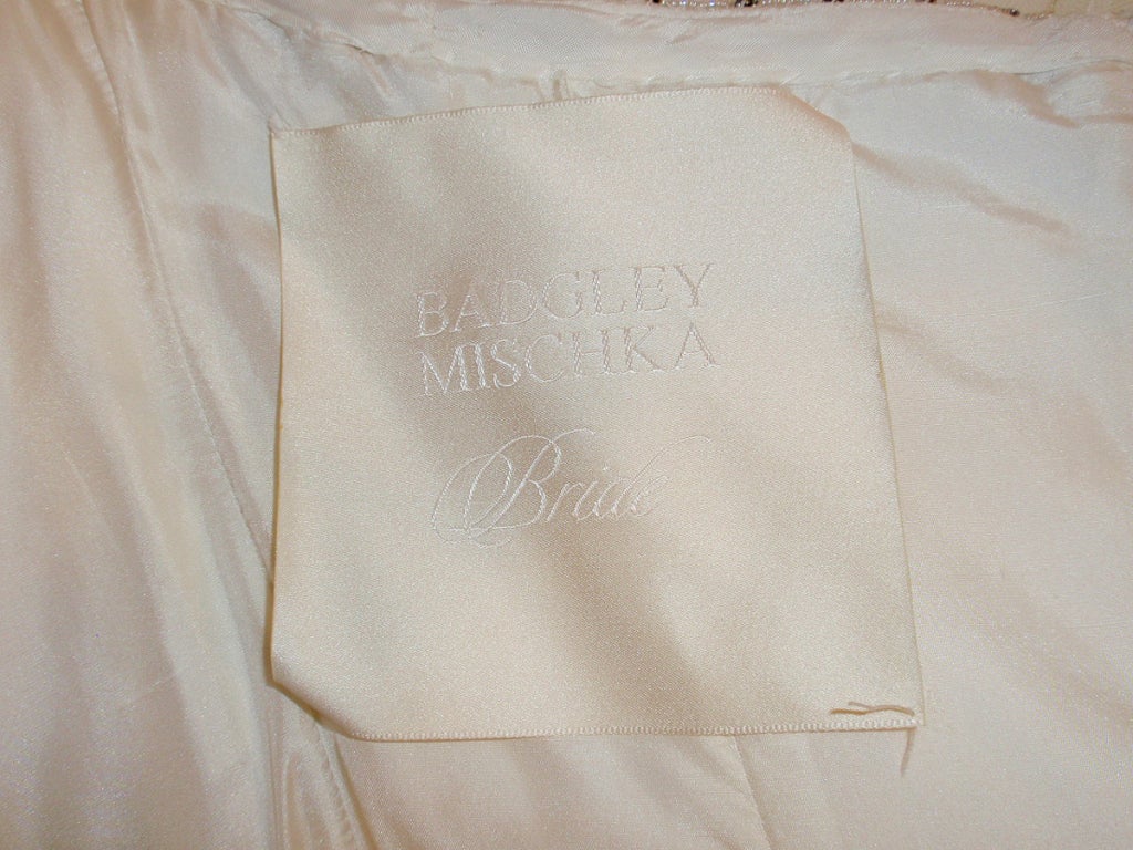 Este es un impresionante vestido de novia de Badgley Mischka. El corpiño está decorado con pedrería y strass, y la falda tiene pedrería y lentejuelas. Hay una enagua de tul para dar volumen. El corpiño está deshuesado.

Medidas:

Busto: