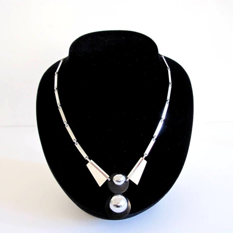 Henkel & Grosse, Pforzheim in Germany, is famous for the work for DIOR Paris.
They worked also in the style of Jakob Bengel.
Chromed metal and galalith. Galalith with signs of age.
Pendant: 4,2 cm / 1,7 in.