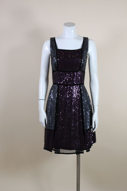 Lovely party dress from Naeem Khan features panels of color-blocked sequins in gunmetal gray and violet, edged in black velvet. Inverted pleats from the waist add an extra flare to the a-line skirt. Fully lined with a back zipper.