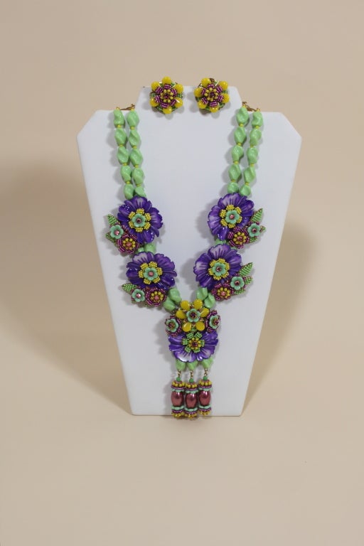 Fantastic statement necklace from iconic designer Stanley Hagler is made from glass beads in shades of violet, apple green and sunny yellow arranged into lovely floral bouquets. Each floral piece is secured to a brass filigree base. Comes with