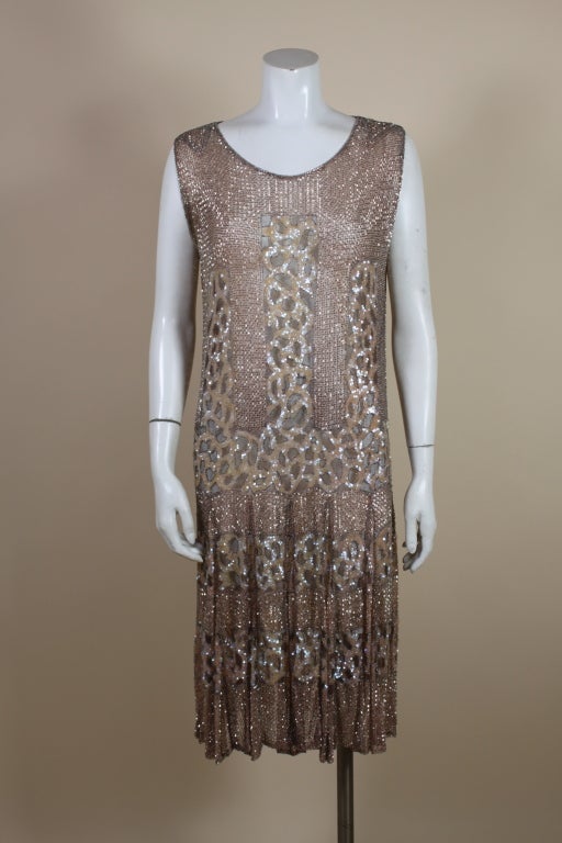 Absolutely THE best and most stunning 1920s flapper dress made from blush pink silk net covered completely with shimmering iridescent pink sequins and silver-lined glass seed beads. Dress is embroidered with a fine, lattice pattern of silver bugle