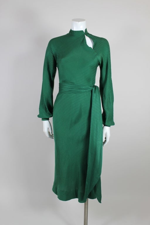Fantastic 1970's bias cut dress from Halston is made from a lovely hunter green silk jacquard in a houndstooth pattern. Dress has a mandarin collar with an asymmetrical peekaboo bias seam. Blouson sleeves fasten at the wrist with snap closures. Two