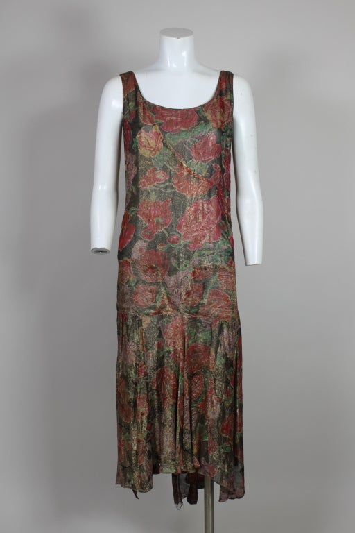 Fantastic 1920’s flapper dress is made from the most gorgeous silk lamé with flowers printed in vivid shades of hot pink, red, lavender, emerald green and sunny yellow shot with metallic gold. Silhouette has an iconic drop waist with V-shaped