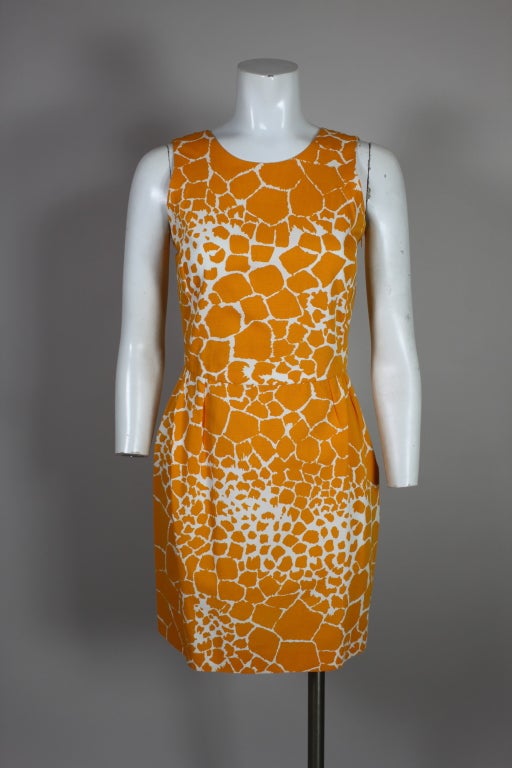 Chic 1960’s inspired dress from YSL is made from a cotton bengaline printed with a bold, graphic giraffe print in bright goldenrod on white. Bodice has princess seams in the front and an illusion wrap back. Fastens with an invisible side zipper.
US