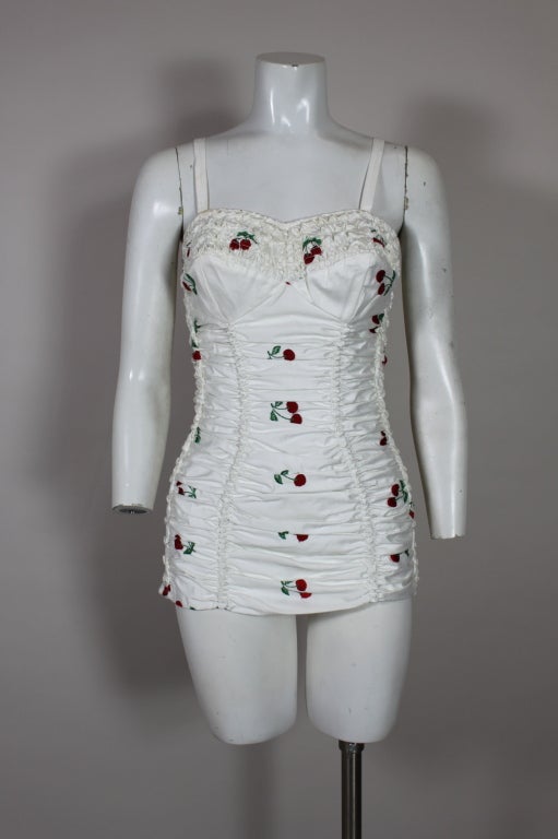 Iconic American swimwear from Jantzen.  Sexy but sweet 50's one piece cotton bathing suit in white with vibrant embroidered clusters of embroidered cherries.   Part of a collection of swimwear that was never worn.  Perfect!!

32