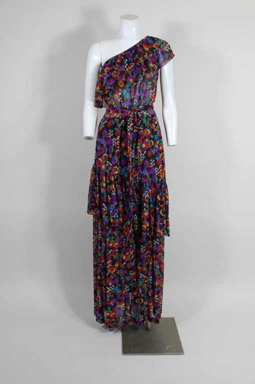 Magnificently colorful abstract printed chiffon 2 piece ensemble from YSL.  The two pieces comprise of a one-shoulder tunic that has an assymetric ruffled neckline and an opposing assymetric hemline, fitted waist on the tunic with a self belt..  The