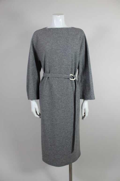 This chic heather gray wool dress from Halston is cut in a relaxed silhouette with raglan sleeves. Elegant, subtly cut neckline looks as though its borrowed from the 1960's. The dress may be worn loose or fastened with a belt produced in
