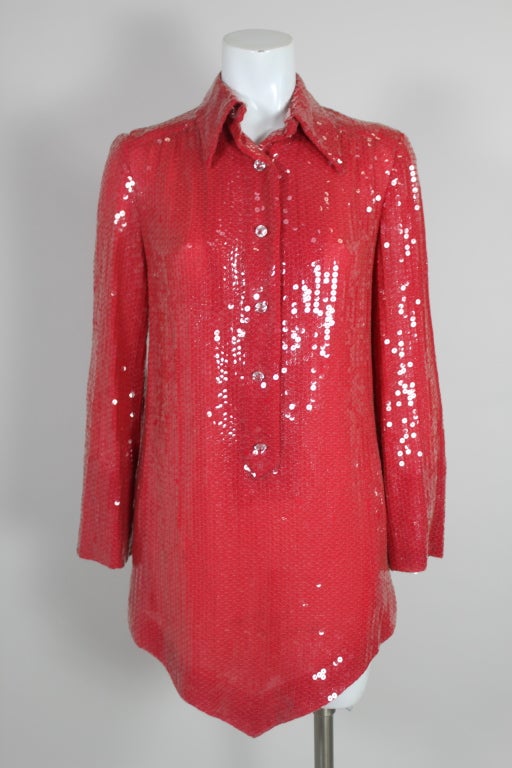 In the classic style and technique of Halston.  Tunic-style with a center point hem. Classic flat sequin detail in fire engine red chiffon.  Button down front with cut glass buttons. Length, at shortest point, 28