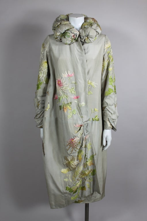 Gorgeous 1920s dove grey silk opera coat with beautifully rendered hand embroidery with a japonaise flair.  Padded and tufted stand up collar adds even more drama as does the asymmetrical side closure with faux buckle.  Lightweight elegance - a