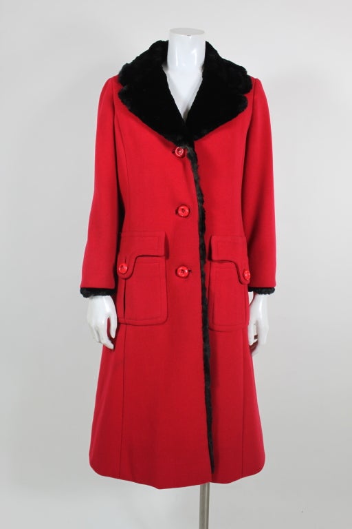 This gorgeous, lipstick-red coat from Pierre Balmain is lined in luscious black fur which peeks out at the collar and cuffs. Cut in a 1960s fit and flare silhouette with Mod patch pocket detailing, the coat has elegant princess seaming and fastens