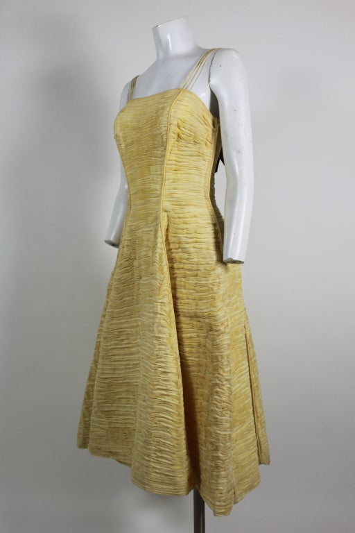 This dreamy 1950's dress was designed by Sybil Connolly, the Irish designer who created fashions for First Lady Jacqueline Kennedy. Made from her signature hand pleated handkerchief linen in a buttery yellow, this dress has a fit and flare