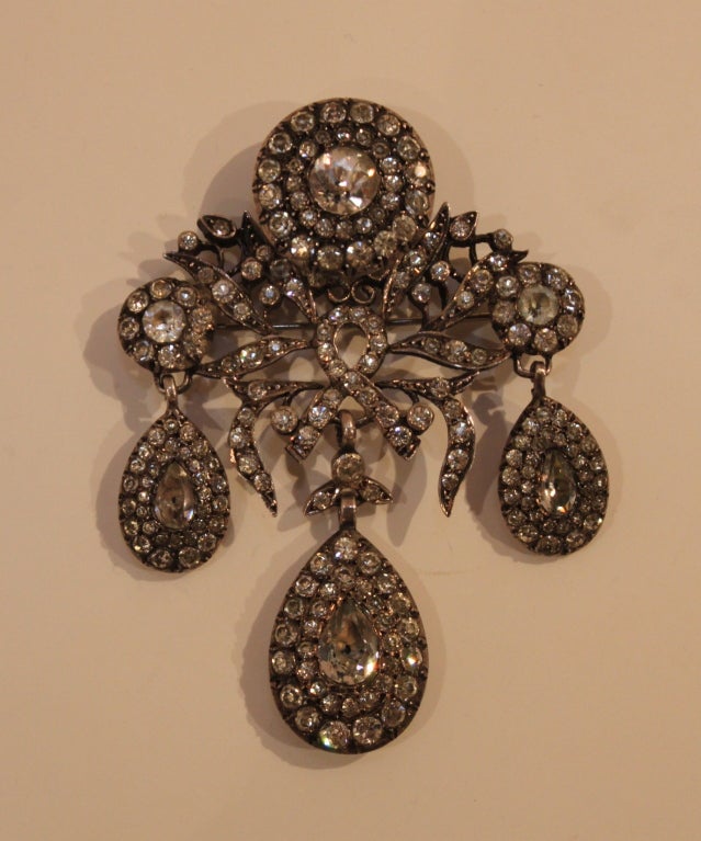 An absolutely stunning piece of Victorian craftsmanship, this brooch is made from fantastic French paste stones (meant to imitate the raw sparkle of diamonds) set in an intricate rhodium setting. This piece may be worn as a brooch or as a pendant.