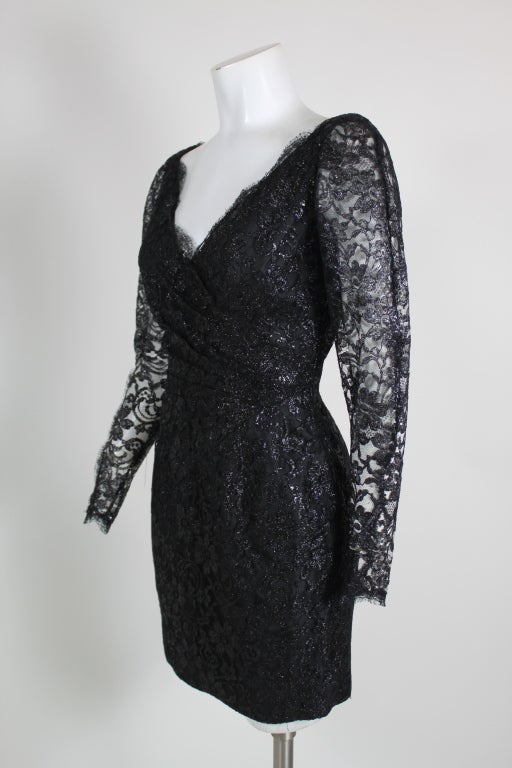 This super-sexy dress from Azzaro puts a sultry spin on the classic little, black dress. Made from luxe, metallic black lace, the dress has sheer sleeves, asymmetrical pleating at the waist and a low v-neck and back. Lined through the body with a