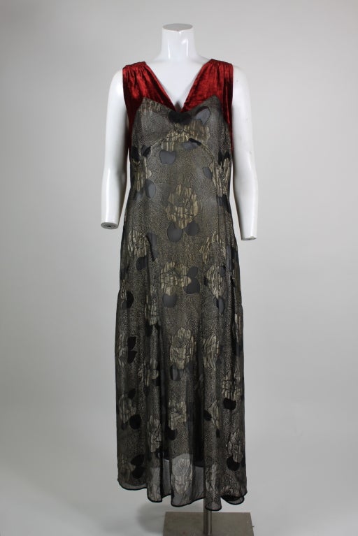1920s elegance in gold lamé with high, Art Deco motif.  Black and gold floral and geometric print. Accented with red velvet shoulders. V-neck line. Couture finishing.