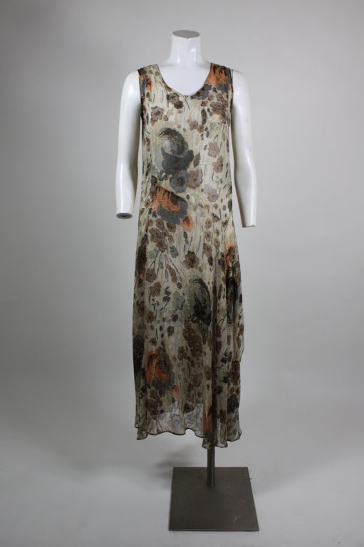 Elegant, sheer floral print deco era gown with flirty flounce at waist. Floral print in browns, greys and pale orange. Slip-on style.