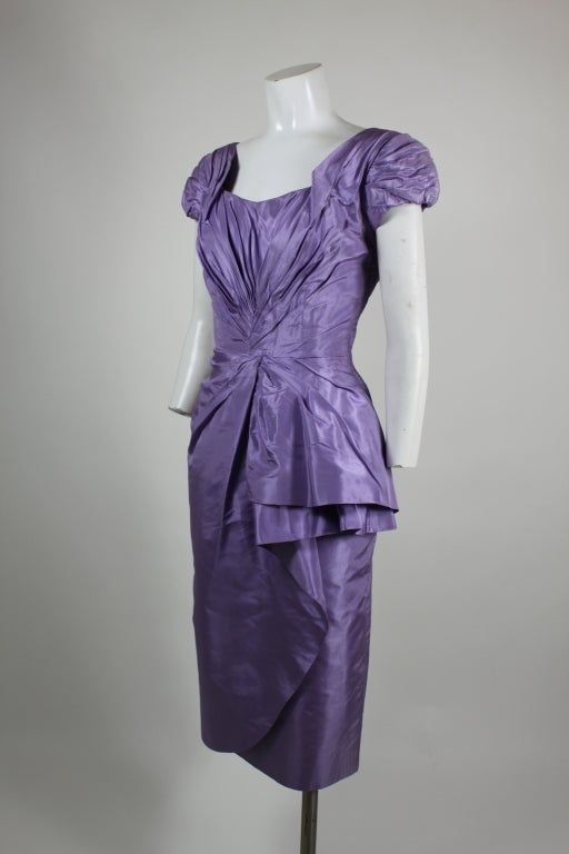 Exquisite Ceil Chapman cocktail frock.  Super sexy 1950s silhouette in a lovely lilac shade of silk taffeta.  Accentuated at bust and waist with a wonderful shirring that cascades down the hip in a playful flounce.