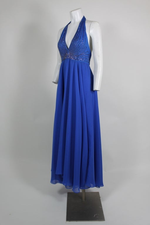 1970s gown in electric blue spangled iridescent radiating rhinestones at halter top.  One of Mr. Blackwell's more glamorous pieces.  Gown is accompanied by a coordinating blue chiffon wrap.  Very California casual dressy or for dancing under the