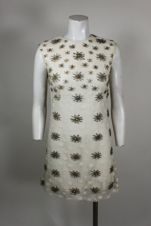 Fabulous mini dress from Bill Blass accented with beading throughout. The pattern is more concentrated at the neckline and disperses toward the bottom, giving the garment a modern edge. Fully lined in silk, zips in back.
