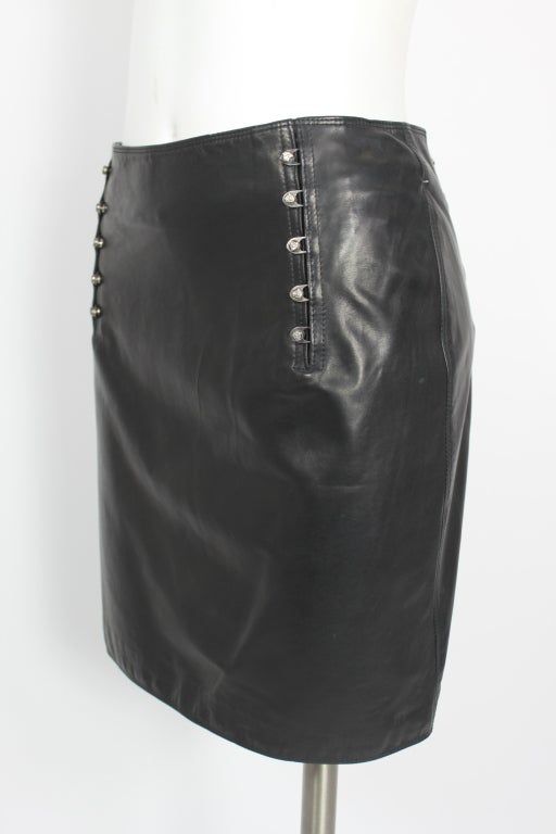 Classic lifetime Gianni Versace black leather mini pencil skirt with metal medusa head accents.