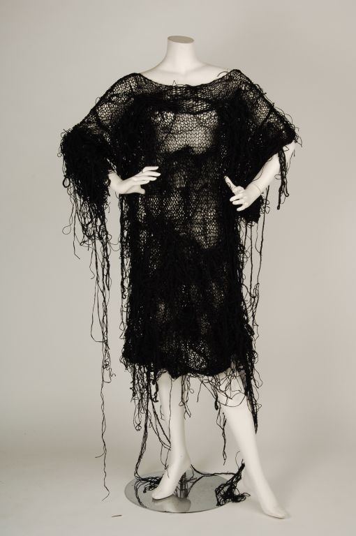 Black handmade, knit dress with loose and irregular knit creating a messy fringe effect. Asymmetrical sleeve length.     
  
Neck opening: 7??
Length: 41?
Width? 25?? x2
Left sleeve, Shoulder to hem: 11?
Left sleeve width opening : 17?
Right