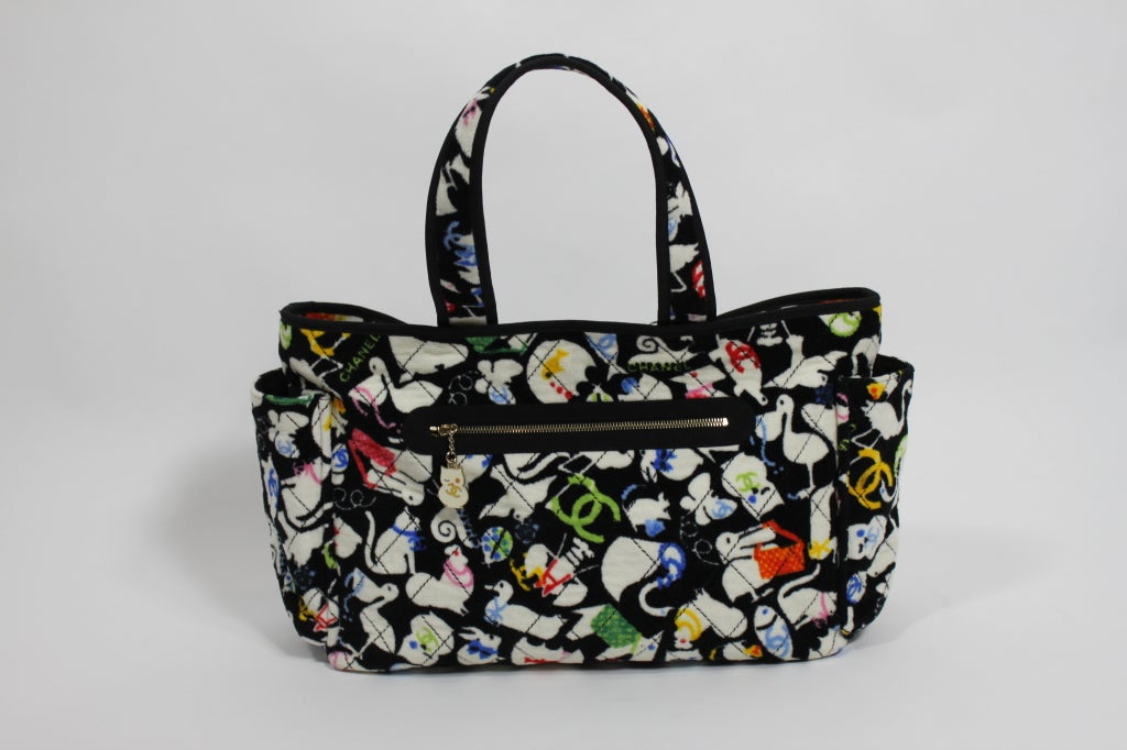 A fun, sweet, and stylish diaper bag from Chanel. Quilted terry printed all over with baby animals and classic Chanel double-C logo. Bottle compartments on either side, as well as compartments in interior. Bag zips closed on top.