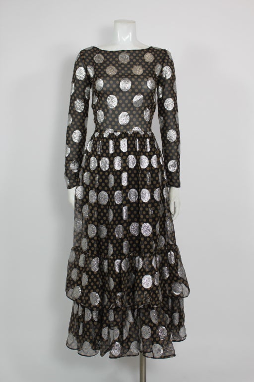 This fabulous dress from Lanvin is covered in silver lurex large scale polka dots over printed chiffon. The chic silhouette is accented by a playful ruffled hem.

Skirt is fully lined.
Zips in back.