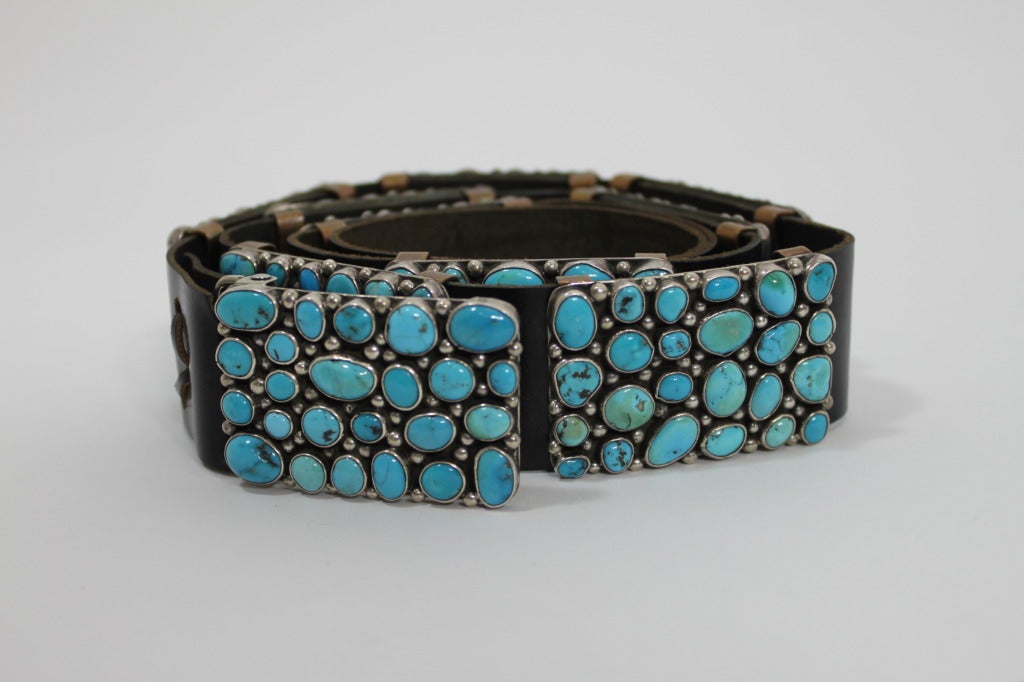 This fabulous Native American natural turquoise belt is a nod to modernist design. Natural turquoise pieces are set in flat bezel sterling silver, whose minimal design highlights the variation in turquoise stones. The concha clusters (10 in total)