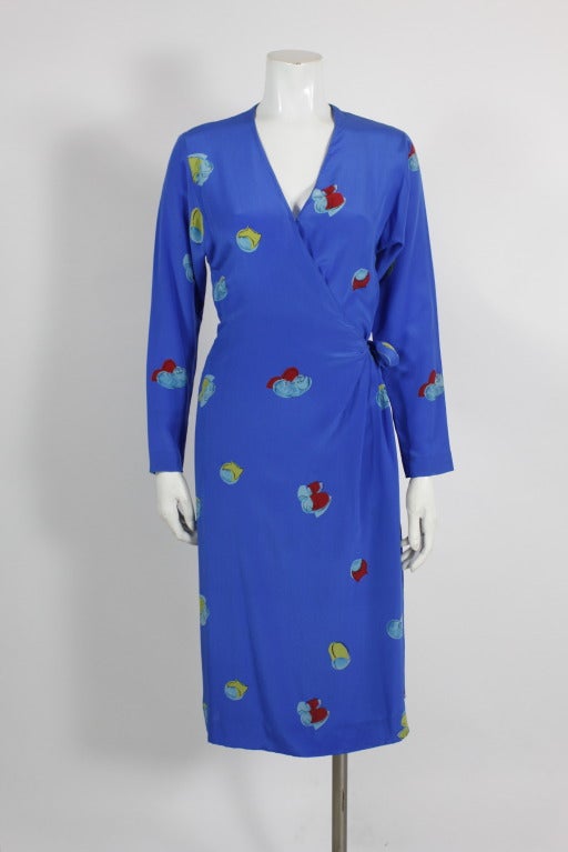 Fabulous silk crepe wrap dress from Halston done in saturated hues of blue, red, and green. Bold, graphic abstract floral pattern throughout. Gathers at waist; hook closure at bust.