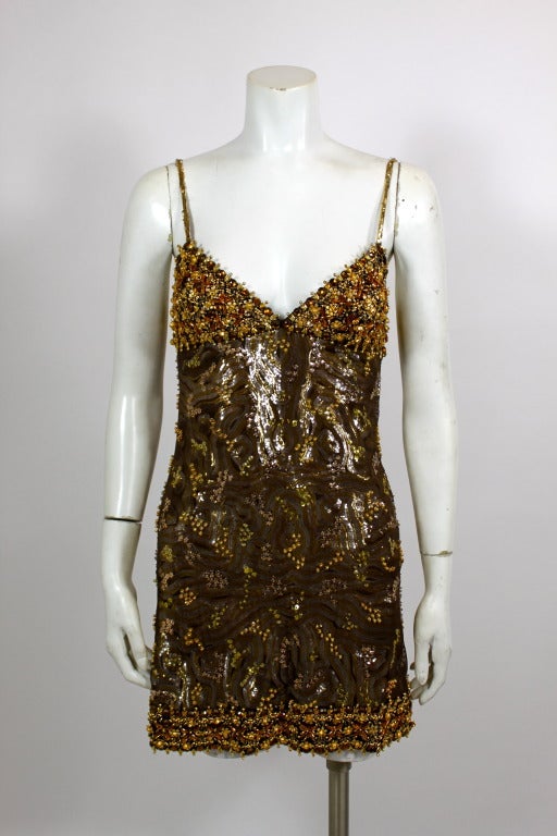 Fabulous bronze and gold-tone party dress from Lancetti done in sequins and ornate beading. A fine layer of silk net tulle covers all-over rows of sequins, giving the dress a muted shimmer. Hemlines adorned with bronze and amber jewels, and straps