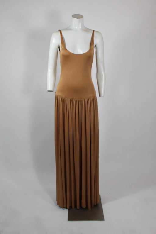 An iconic gown from Halston done in an almost iridescent bronze silk jersey. Low-cut, luxe, and ultra-sexy, this gown is equal parts body-con and ethereal. 

Measurements as follows:
Bust: 34 inches*
Waist: 26 inches*
Hip: 40 inches*
Length,