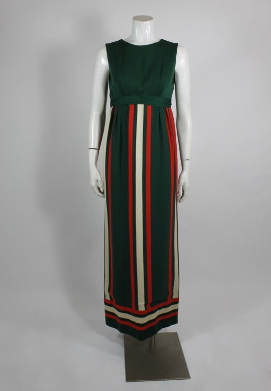 Known for dressing the world's most socially prominent women, James Galanos creates ready-to-wear garments with a couture sensibility. This green wool gown is done with orange and white graphic stripes and ties in the back with a green chiffon bow.