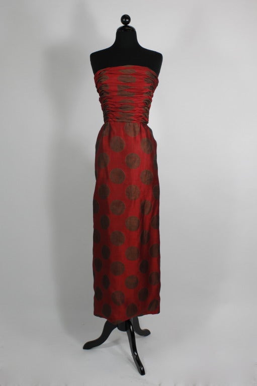 Silk raspberry polka dot gown from Adolfo done with a ruched bodice and a waterfall of ruffles in the back. Gown zips in back with a bow that attaches over it (please note that zipper is fully functioning; it just does not zip all the way up on the