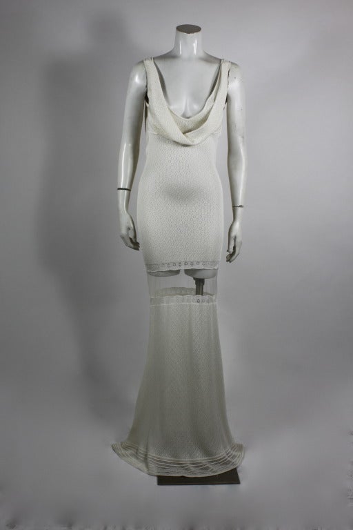 White floral knit gown from John Galliano done in designer's iconic bias cut. Galliano masterfully updates the 1930s-inspired silhouette by using a luxe knit fabric and incorporating a sheer horsehair panel just below the