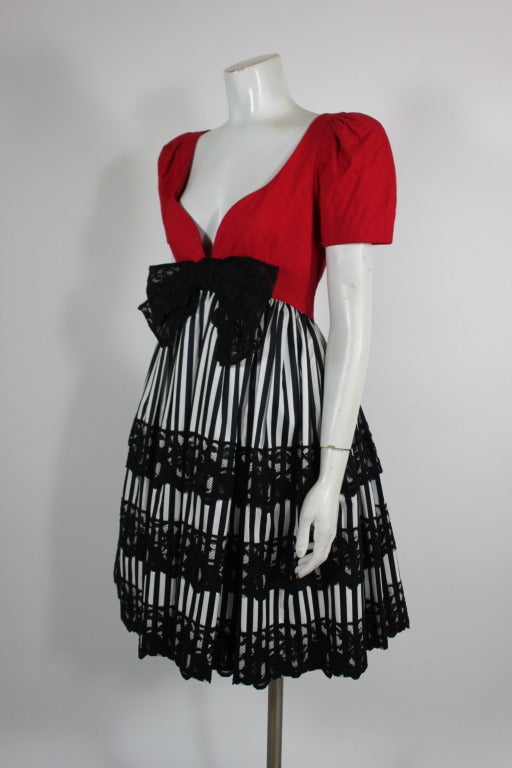 A red party dress from Adele Simpson done with a full black and white striped skirt. The skirt is embellished with beautiful black lace; there is a layer of tulle underneath to give the skirt extra body and fullness.

Measurements--
Bust: 34 - 36