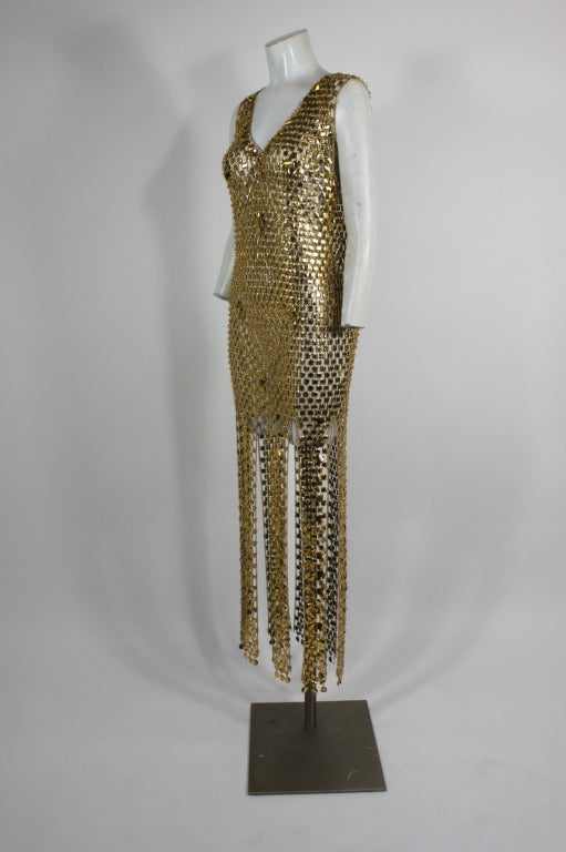 This wonderful gown is done in the style of Paco Rabanne. with golden paillettes linked together by gold-tone metal rings. The pattern is mixed with alternating larger pieces to give it some depth. Skirt is paneled, with an almost medieval