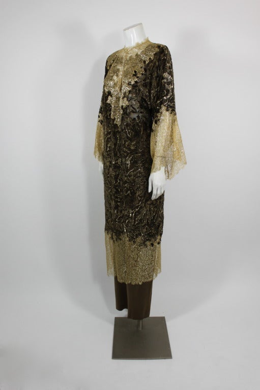 A lovely ensemble from Oscar De La Renta. Caftan is done in brown shaved velvet and trimmed with gold metallic lace in an almost Western motif. Ensemble includes brown silk trousers. Labeled a Size 12.

Measurements--
Bust: 40 inches
Waist: 38