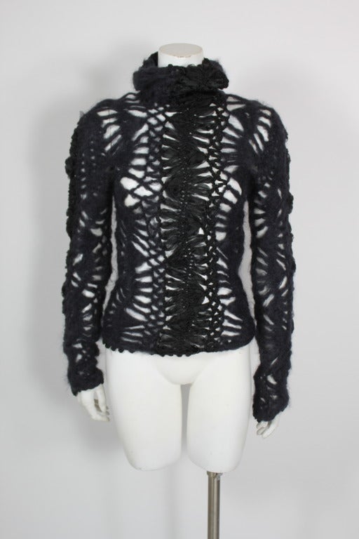 A wool cashmere knit cowl-neck sweater from Christian Dior. Knit pattern is interwoven with black ribbon. Bell sleeves.

*Please note that the sweater does have some stretch to it, but not much.

Measurements--
Bust: 32 inches
Waist: 28