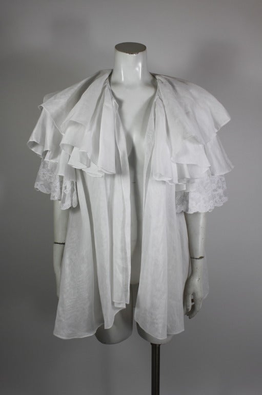 Luxe, lightweight, and chic white organza ruffled jacket from Gianfranco Ferré. Jacket is done in trapeze silhouette, with tiers of ruffles. Sleeves have white lace tier. 

-No closure
-Sleeve hits at elbow
-A-line