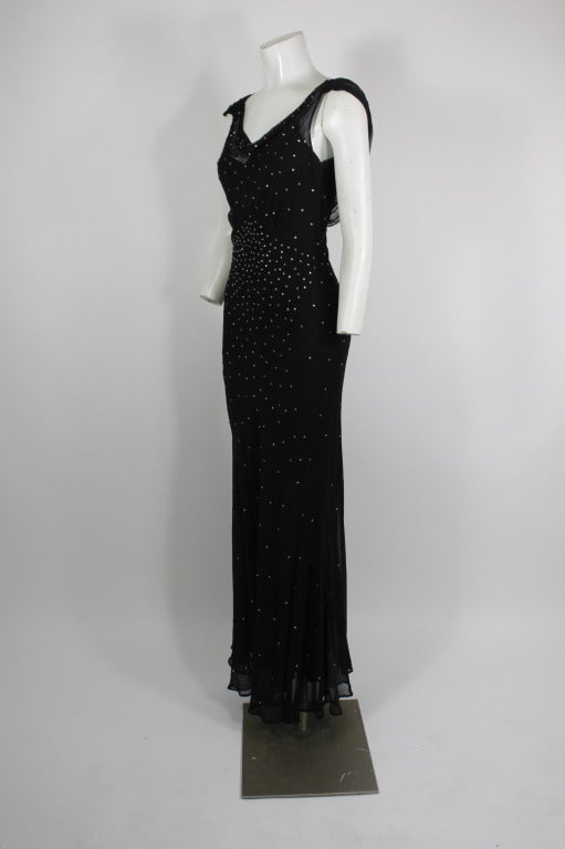 A lovely gown from Norma Kamali. Done in black chiffon and accented with rhinestones, the silhouette is in the style of a 1930s bias-cut gown. Has full length slip.

Marked a US size 4.