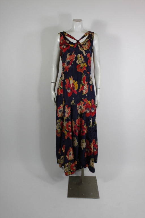 Lovely 1930s bias-cut gown done in luxurious blue silk with large scale floral-print throughout. Gown has asymmetrical hemline and flowing drapes in the back. Unlined, and slip-on style: without zipper or closure.
