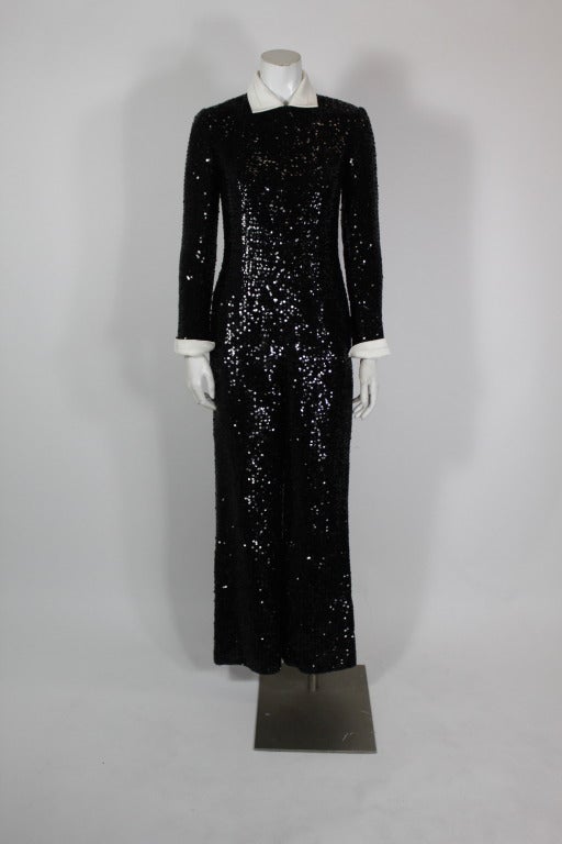 Black sequined tuxedo jumpsuit from Jean Patou. Jumpsuit is fully covered in sequins, and has a detachable cream hammered satin collar. Pants are slightly wide-leg.

-Fully lined
-Zips at wrists
-Zips in back
-Labeled size