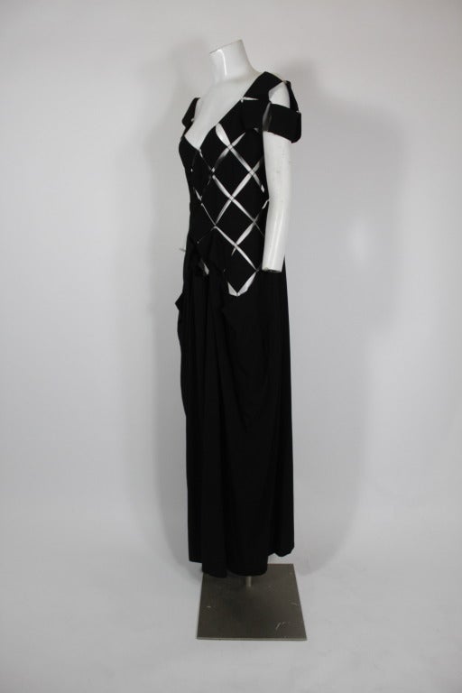 A master of construction and drape, Yohji Yamamoto's work is consistently stunning. This black rayon gown is done true to Yamamoto form, with a diamond grid bodice and draped and gathered skirt. The grid closes in back with lobster claw hooks and