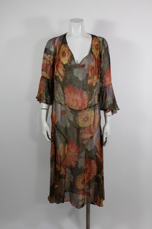 An absolutely stunning 1930s floral lamé three-quarter length sleeve garden dress. Large-scale pink, blue, and yellow flowers cover the golden leaf lamé chiffon.