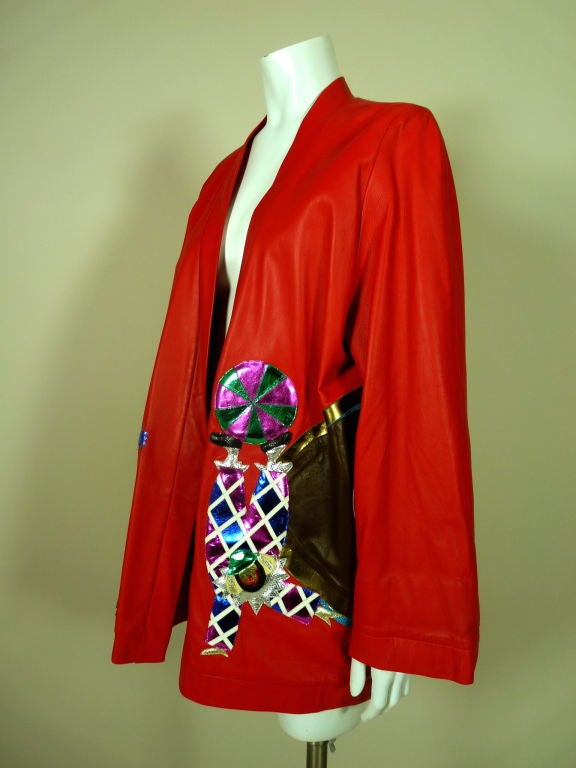 Whimsical over-sized tomato red leather jacket with metallic circus themed appliqués. Appliqués are done in an array of colored and textured leathers including metallics, reptile skins and matte & shiny finishes. Dimensional appliqués are further