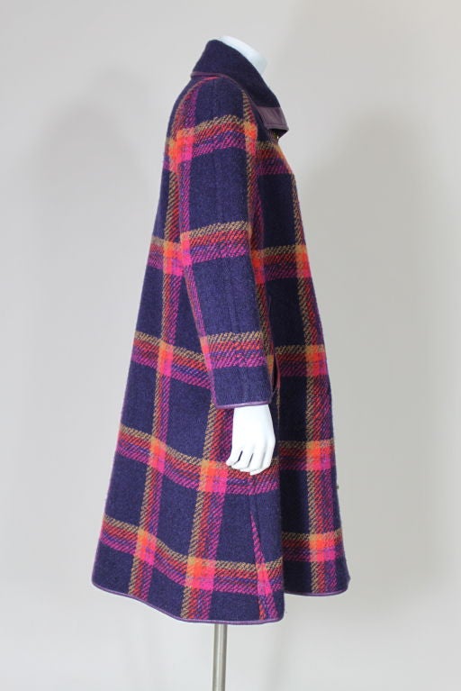 Richly colored plum, hot pink and orange oversized plaid wool coat from Bonnie Cashin trimmed in purple leather with two slash welt pockets and fold over collar. Iconic Bonnie Cashin brass closure hardware.<br />
<br />
Measurements:<br />
Bust